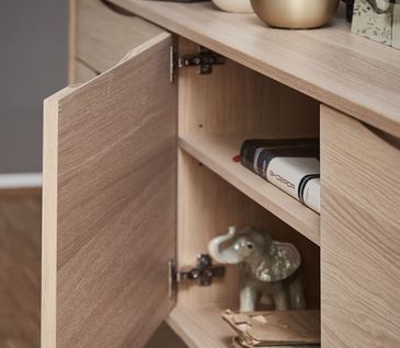 Hölzernes, dekoriertes Sideboard mit einer geöffneten Tür