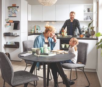 Familie mit am Essplatz in weißer Küche