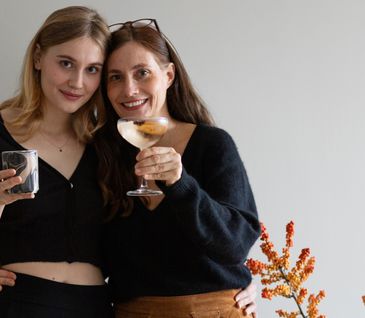 Nicole Zweig und Tochter mit Gläsern vor herbstlicher Dekoration