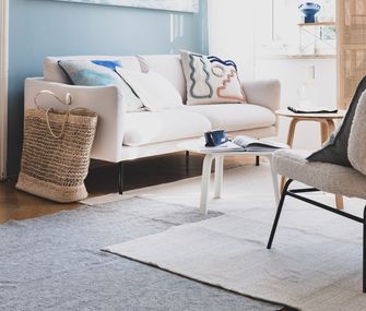 Wohnzimmer mit Couch und Stuhl in sommerlich eingerichteter Wohnung von Nicole