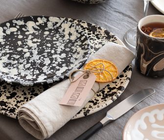 Nahaufnahme getrocknete Orangenscheibe als Serviettenring mit Namensschild