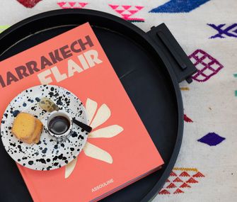 Buch über Marrakech Flair auf einem Couchtisch mit buntem Teppich