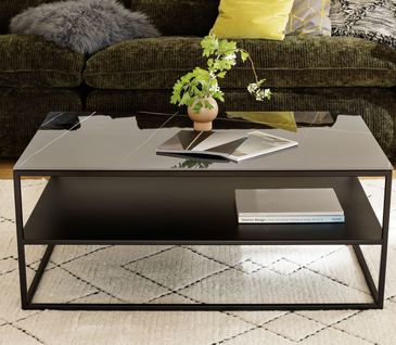 Schwarzer Couchtisch mit einer Platte im Marmor-Style und einer extra Ablageplatte