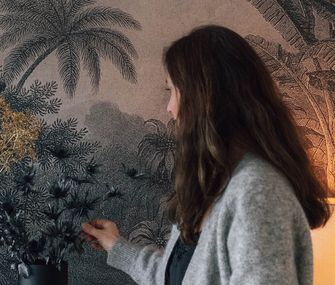 Nicole Zweig platziert Trockenpflanzen vor einem Dekobild