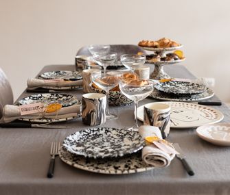 Schwarz-weißes Geschirr mit Servietten und selbstgebastelten Serviettenringen aus Orangenscheibe und Paketschnur