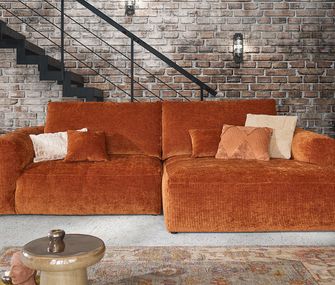 Rost-Rotes Sofa im Retro-Stil und organischen Formen in urbanem Wohnzimmer.