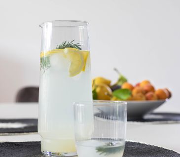 Selbstgemachte Limonade mit Zitrone und Rosmarin in einer Glaskaraffe.