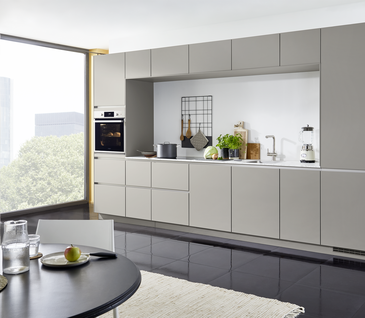 Minimalistische Küchenzeile in Hellgrau mit viel Stauraum und Essbereich von der Europa Möbel Kollektion