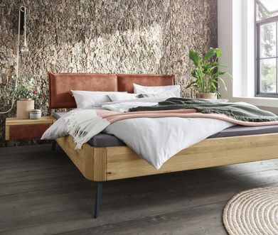 Doppelbett mit roter Rückenlehne und Holzgestell vor Wand in Naturstein-Optik