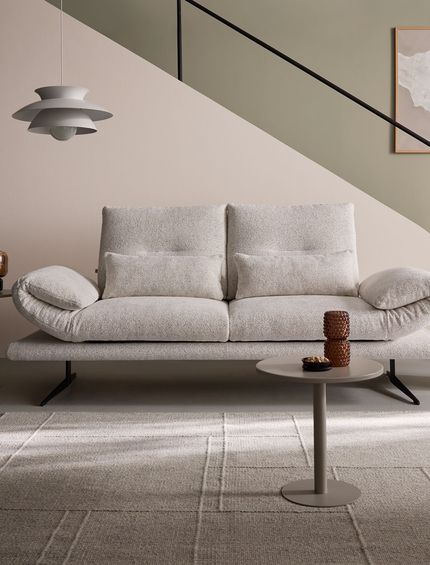 Modernes 2-Sitzer-Sofa mit beigem Stoffbezug in elegantem Wohnzimmer.