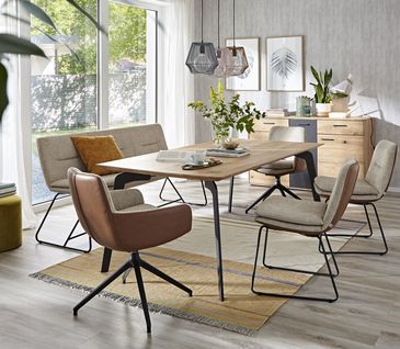 Esszimmer mit Bänken und Stühlen in den Farben Braun und Beige.