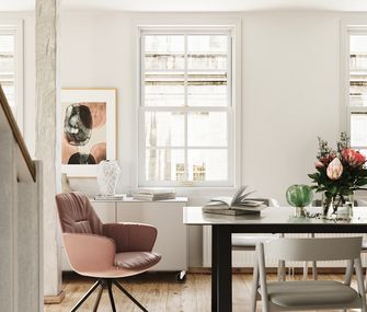 Esszimmertisch mit hellbraunem Armlehnstuhl und weißem Holz-Stuhl im Skandi-Look.