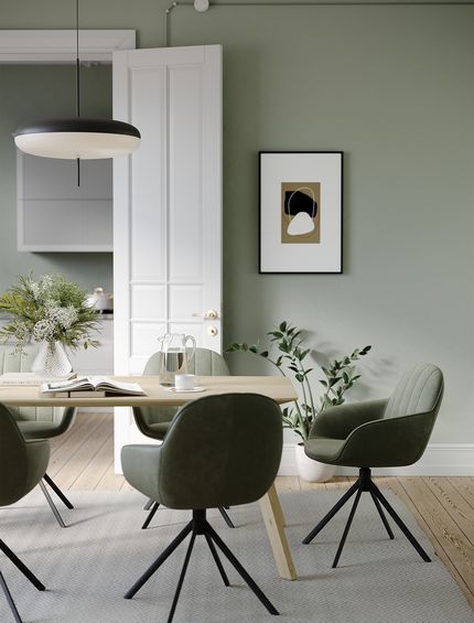 Waldgrüne Esstischstühle aus Leder an Esstisch aus Holz in Esszimmer.