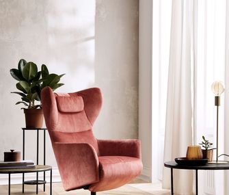 Einrichten in Trendfarbe Terrakotta mit gemütlichem Sessel und Beistelltischen.