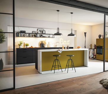 Moderne Inselküche mit weißem Tresen, schwarzer Küchenzeile und ohne Oberschränke.