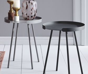 Zwei graue, runde Beistelltische mit Dekoration