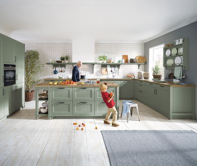 Salbeigrüne Landhausküche mit Arbeitsplatte aus Holz.
