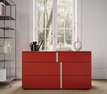 Rot rundet jede Inneneinrichtung ab und setzt Farbreize, die für unser Auge angenehm sind. Kommode in kräftigem Rot in modernem Wohnzimmer.