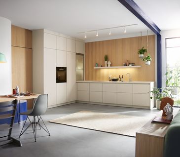 Moderne, weiße Küche in L-Form mit Holzakzenten.