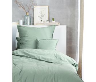 In frischem Mintgrün oder reinem Weiß. Hochwertige Bettwäsche von Hahn entdecken. Detailbild von Bett im Schlafzimmer mit mintgrüner Bettwäsche.