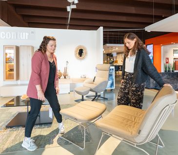 Kundin wird von Möbelverkäuferin im Einrichtungshaus beraten.