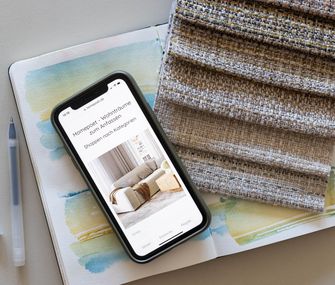 Handy mit Homepoet Online-Shop neben Stoffmuster.