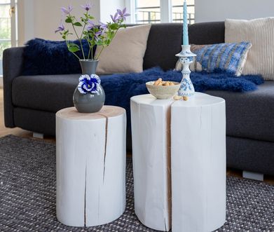 Zwei Holztische aus einem Baumstamm, weiß lackiert.