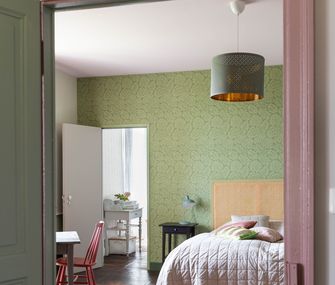 Schlafzimmer in grün und rosa eingerichtet.