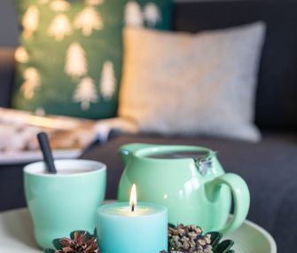 Teekanne auf Beistelltisch mit Kerze