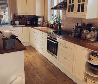 Weiße Landhausküche mit Kücheninsel.