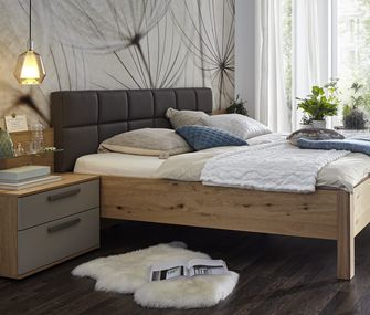 Zwei Betten und unterschiedliche Nachttische nebeneinander: Weiß und in Holzoptik