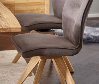 Achten Sie beim Stuhl, Sessel oder Sofa mit Stoff immer auf die Pflegehinweise des Herstellers! Dunkelbrauner Esszimmerstuhl am Holz-Esstisch mit braunem Stoffbezug