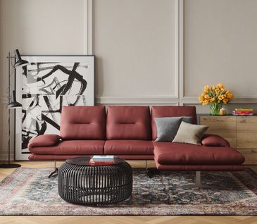 Endlich wieder Mut zur Farbe: Mit Trendfarbe Rot in 2024! Rotes Ecksofa in Altbau-Wohnzimmer mit schwarzem Beistelltisch und Kommode aus Holz.