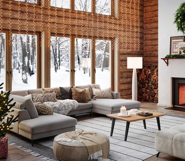 Wohnzimmer im Chalet-Stil, weihnachtlich dekoriert mit Weihnachtsbaum, Lichterketten und vielem mehr.