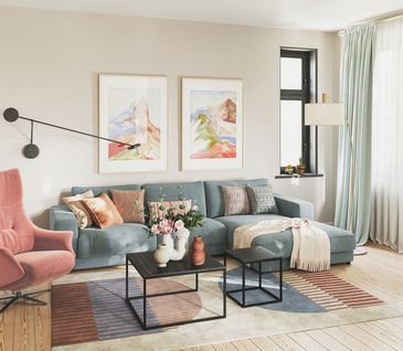 Modernes Wohnzimmer mit hellblauem Ecksofa und Relaxsessel in Rose.