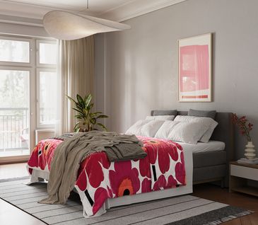 Rot ist auch im Schlafzimmer gern gesehen. Entdecken Sie die Welt der ultimativen Entspannung in Ihrem Zuhause mit akad'or night. Schlafzimmer mit grauem Bett und roter Blumenbettwäsche