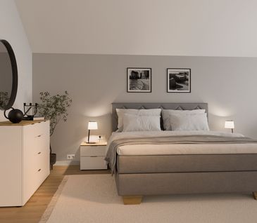 Taupesfarbenes Boxspringbett in hellem Schlafzimmer.