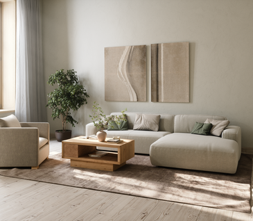 Hellgraues Ecksofa mit Kissen und Deko in der Farbe Cappuccino.