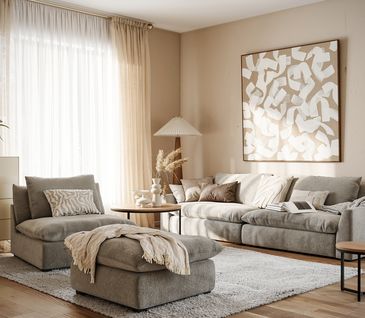 Gemütliches Wohnzimmer in Beige und Grau eingerichtet mit Sofa, Sessel, Hocker, Highboard und Couchtischen.