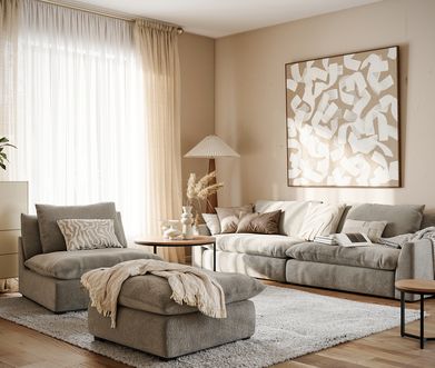Gemütliches Wohnzimmer in Beige und Grau eingerichtet mit Sofa, Sessel, Hocker, Highboard und Couchtischen.