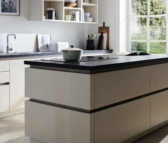 Mach deine Küche zum geselligen Zentrum deines Zuhauses! Weiße Küche mit Kochinsel und schwarzer Arbeitsplatte