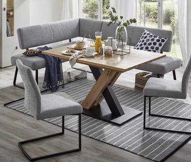 Gepolsterte Eckbank in Grau mit zwei anderen Esszimmerstühlen beim Frühstück