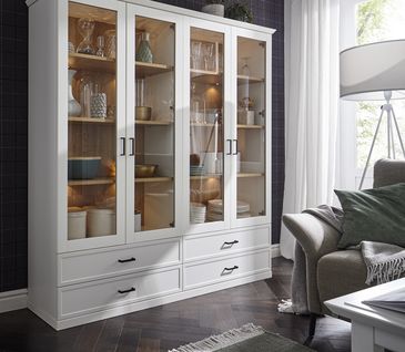 Eine weiße Vitrine mit beleuchteten und dekorierten Einlegeböden