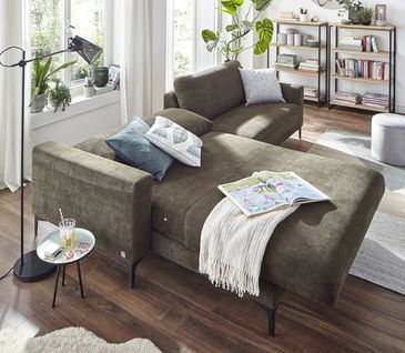 Grünes Stoffsofa mit Relaxfunktion in modernem Wohnzimmer.