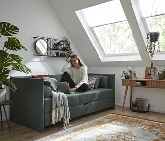 Dunkelgrünes Polsterbett, welches in Jugendzimmer als Sofa und Bett genutzt wird