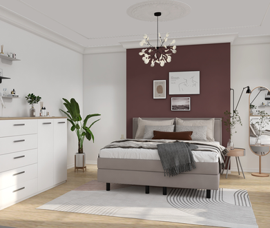 Schlafzimmer mit grauem Boxspringbett vor weinroter Wand, mit weißem Sideboard.