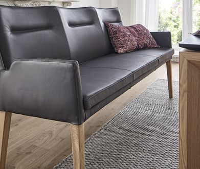 Nahaufnahme einer Sitzbank im dunkelbraunen Echtleder mit Kissen