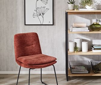 In einem Bücherregal findet sich auch Platz für CDs, DVDs oder Dekoration Regal mit hölzernen Einlegeböden und schwarzem Metallgestell neben einem roten Stuhl