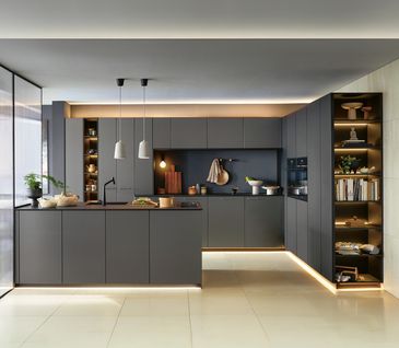 Große, luxuriöse Küche in schwarz mit beleuchteter Fußleiste.