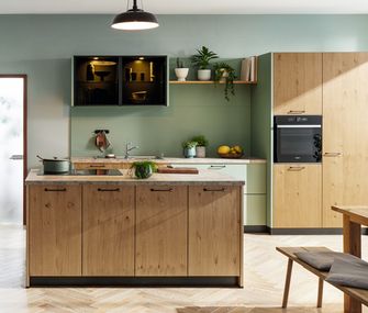Familienküche aus natürlichem Holz und salbeigrüner Wand
